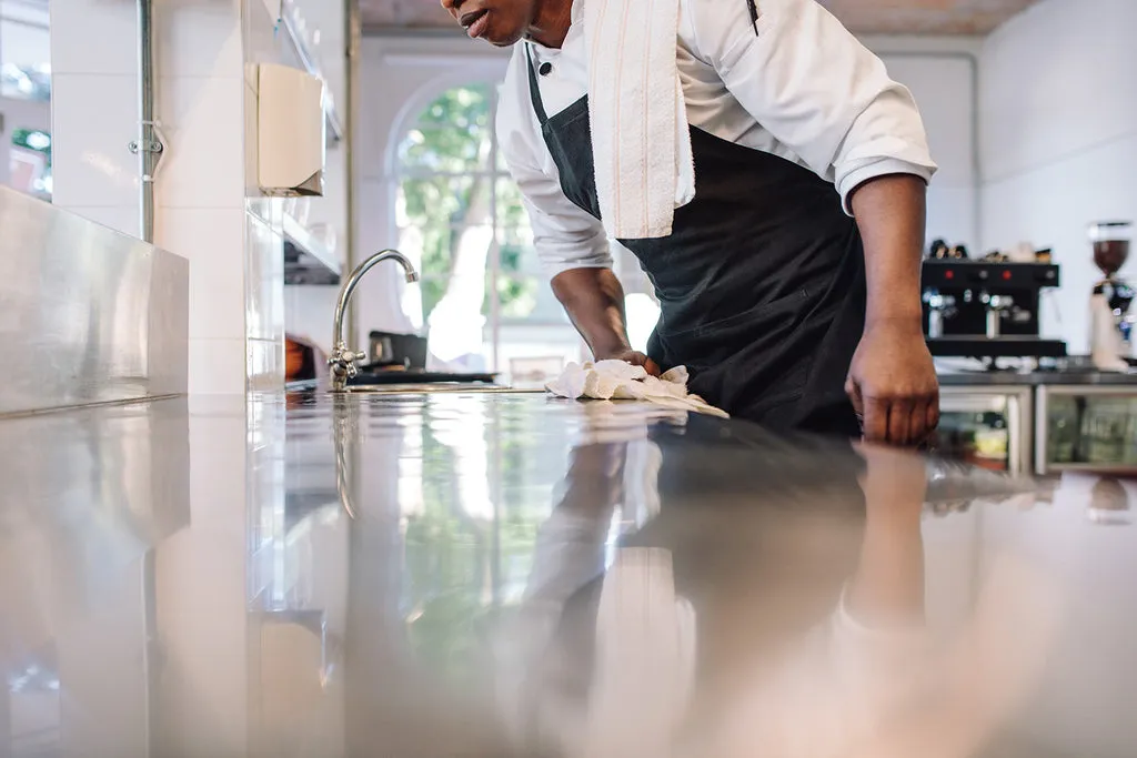 Wiping down a kitchen counter with Restore Naturals All Surface Cleaner